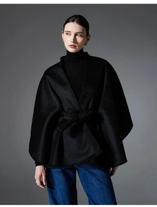Détail d'un manteau cape noir en laine double face avec une ceinture assortie à la taille