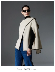 Detail showing high-quality beige wool poncho with black contrast whipstitch craftsmanship