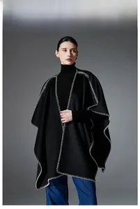 Close-up of black double-sided wool cape featuring white contrast stitching details