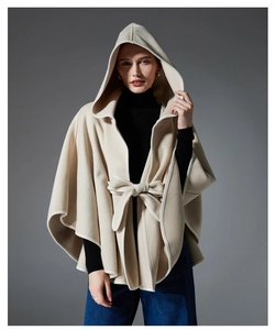 Detail of elegant oatmeal hooded poncho cape featuring a stylish waist tie and bow
