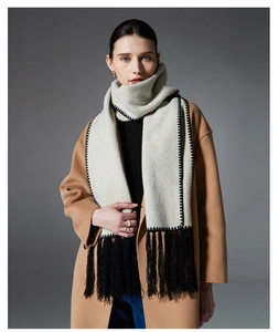 Detail shot of light grey scarf with black tassel fringe and elegant lock-stitch edges