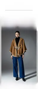 Detail of camel hooded double-sided wool cape with white piping and waist belt tie