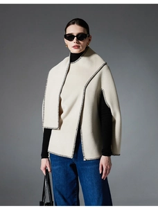 Detail of cream whipstitch cape shawl with black contrast stitching for autumn outfits
