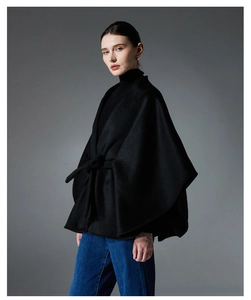 Détail de la texture du manteau cape noir en laine avec ceinture élégante à nouer