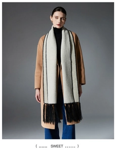 Close-up of winter solid color scarf featuring detailed black stitching and long tassels