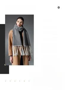 Detail view of a long grey winter scarf featuring long white fringe tassels for a Nordic look