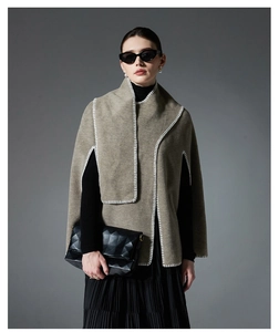 Detail view of grey wool cape with white blanket stitch edges and elegant drape