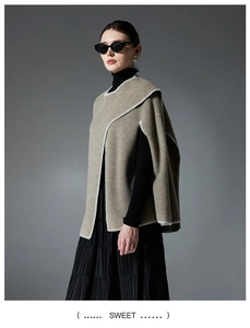 Detailed view of khaki knit poncho featuring distinctive white contrast stitching accents