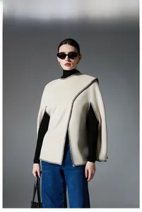 Detail showing high-quality beige knit shawl with contrast black blanket stitch edges