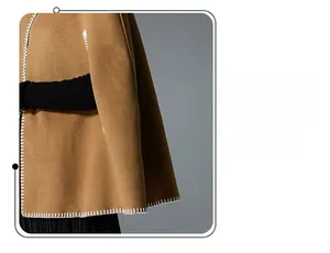 Close-up of camel poncho cape featuring decorative white contrast stitching and wool texture