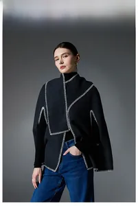 Close-up of a premium black wool cape with white whipstitch edging and slit sleeves