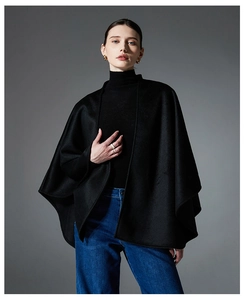Détail de l'élégant manteau cape noir en laine avec manches drapées pour femme