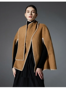 Detailed view of hand-stitched white edges on a premium camel-colored wool poncho cape