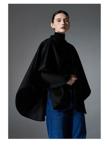 Détail d'un châle en laine noire double face avec une silhouette de cape minimaliste