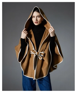 Detail of camel hooded wool shawl featuring white contrast piping and waist bow tie