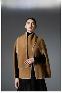 Detail shot of camel wool shawl with white blanket stitch embroidery at the edges