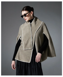 Detail view of the bold white hand-stitched seams on a gray wool cape shawl