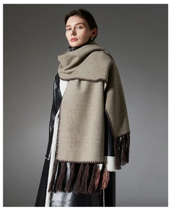 Detail of light coffee scarf with dark brown hand-stitched edges and long fringes