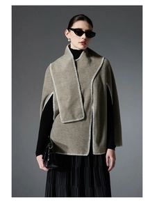 Detail of premium khaki poncho featuring decorative white contrast stitching on the edges