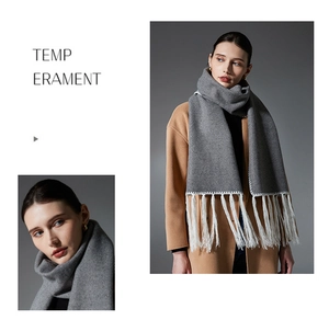 Detail of grey winter scarf with white fringe tassels and handmade edge stitching