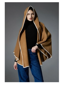 Detail of camel wool-blend hooded shawl with white contrast trim and high-density fabric texture