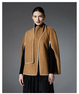 Detail of camel wool-like poncho featuring white contrast stitching on the edges