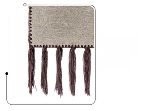 Detail of light grey wool scarf showing brown hand-knotted tassels and stitching