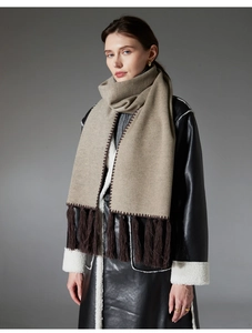 Detail of khaki scarf with brown wavy stitching and long decorative fringe tassels