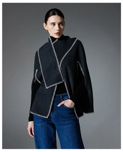 Detail view of premium dark grey wool cape with white hand-stitched blanket edges