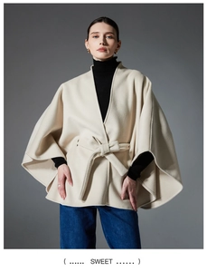 Detail eines beigen Poncho-Mantels mit verstellbarem Bindegürtel für eine feminine Form