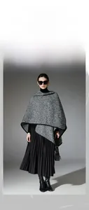 Detail showing high-quality black and white boucle yarn shawl with sleek black piping