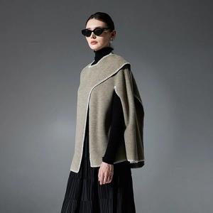 Elegant beige knit poncho shawl with white whipstitch edge and side slits for a loose fit