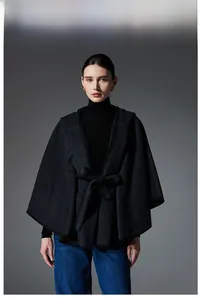 Detail view of a hooded wool cape with waist belt and premium black piping finish