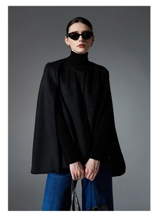 Detail of a black double-sided wool sleeveless cape jacket with side slits for women