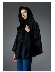 Detail of elegant black hooded wool blend poncho with belted waist for autumn winter