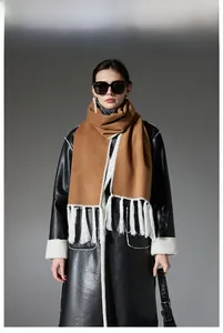 Detail of camel wool scarf with white zigzag embroidery and long decorative tassels