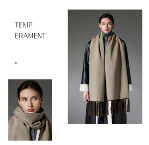 Detail of camel fringe scarf showing contrast zigzag stitching and premium texture
