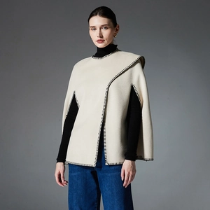 Elegant beige poncho cape with black blanket stitch edges for autumn and winter fashion