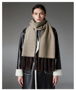 Detail of khaki winter scarf featuring deep brown stitching and long fringe trim