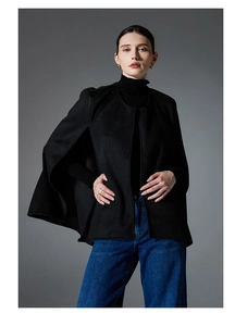 Detail of a black sleeveless wool cape coat with stylish side slits and a round neckline