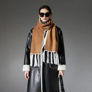 Sciarpa marrone effetto cashmere con nappe bianche su un cappotto in pelle nera