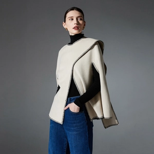 Elegant beige knit poncho with black contrast stitching for women's autumn winter fashion
