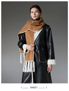 Detail of camel fringe scarf paired with a black leather jacket and white faux shearling lining