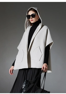 Détail du gilet cape à capuche en laine gris clair avec de grandes poches latérales symétriques