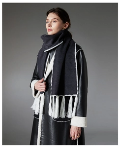 Detail of high-density dark grey scarf with contrast white stitching and long fringes