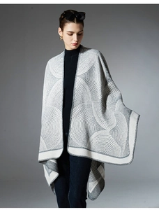 Close-up of geometric jacquard pattern and edge stitching on a knit grey wool shawl