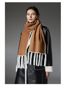 Detail of camel scarf featuring white fringe hem and decorative contrast wavy stitching