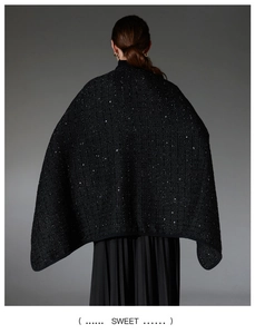 Detail of black sequined wool shawl showing elegant shimmer and textured woven fabric