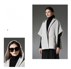 Gros plan du poncho en laine gris à capuche avec grandes poches et finitions soignées