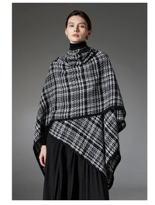 Detail of the elegant black and white plaid tweed poncho cape with black hemmed edges